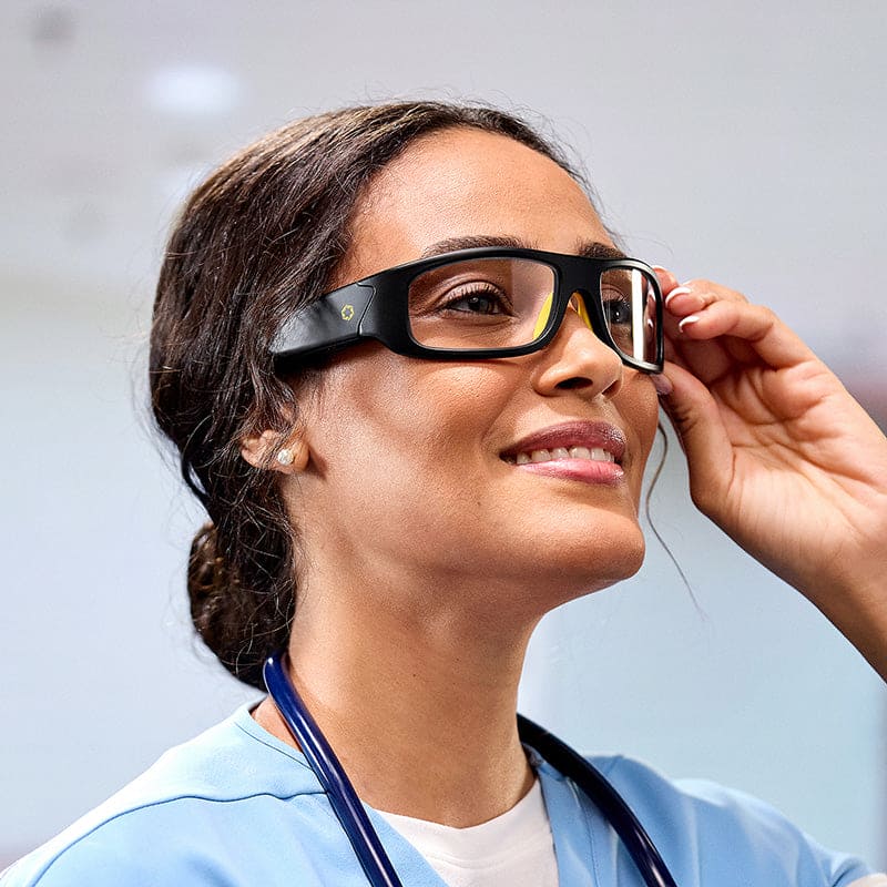 Woman in scrubs adjusting Lucyd Armor Slim Photochromic audio glasses