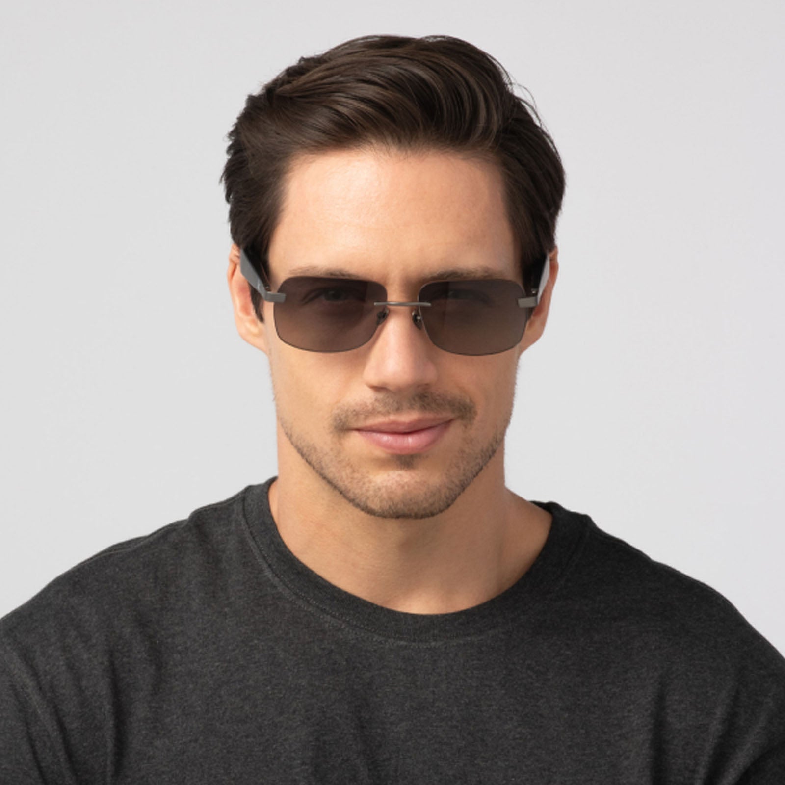 A man with short brown hair wears Eddie Bauer Horizon Bluetooth smart glasses and a dark gray t-shirt, looking directly at the camera against a plain light background.