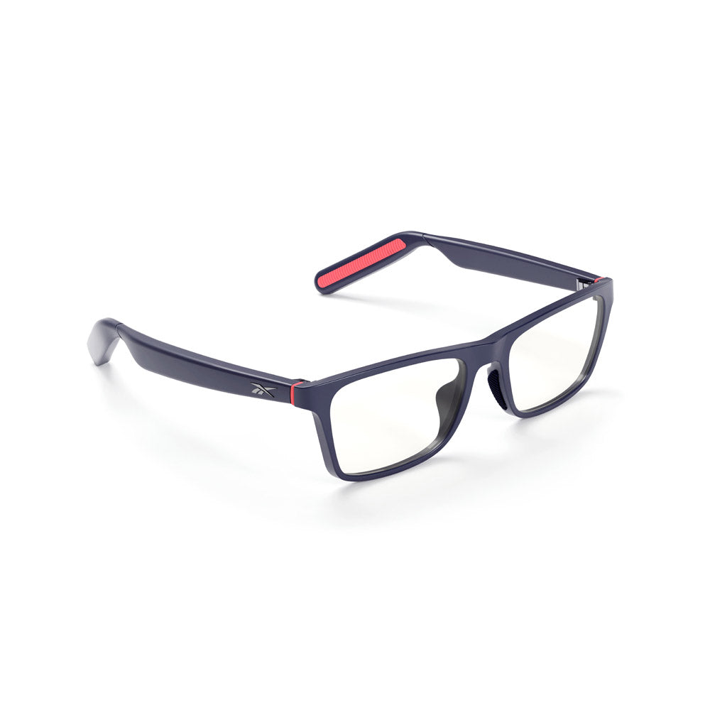 Reebok Dash smart glasses feature a navy blue rectangular frame with clear lenses, red temple accents, and a small white logo. Designed for blue light protection, they're shown on a white background.