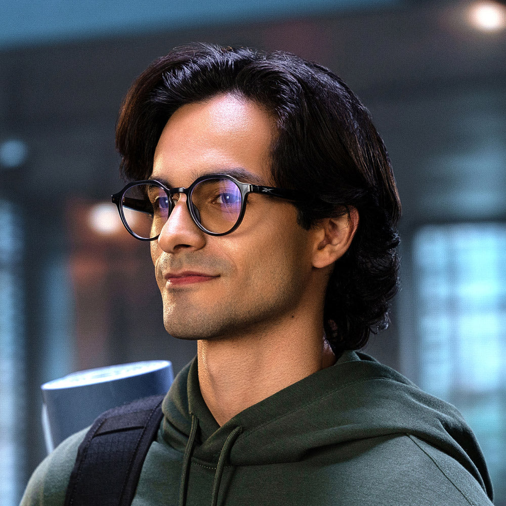 The Reebok Jet eyewear features round, clear lenses and transparent gray frames with black temples that have textured grips at the ends. Shown on a white background, these glasses offer a stylish, privacy-focused design.