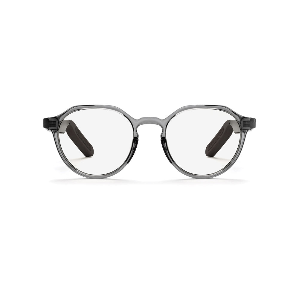 The Reebok Jet smart glasses feature round, clear lenses with a transparent gray frame and black temple arms, offering privacy-focused eyewear technology. Displayed against a white background.