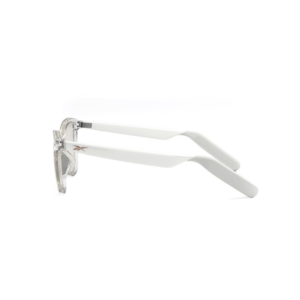 Side view of Reebok Shine smart eyewear in white, with clear rims and solid white arms, featuring a small metallic Reebok logo near the hinges, displayed on a white background.