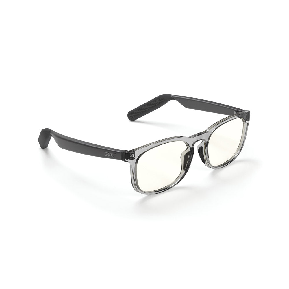 Reebok Thunder smart glasses feature clear frames, black arms, slightly tinted lenses, and discreet open-ear audio technology, shown on a white background.