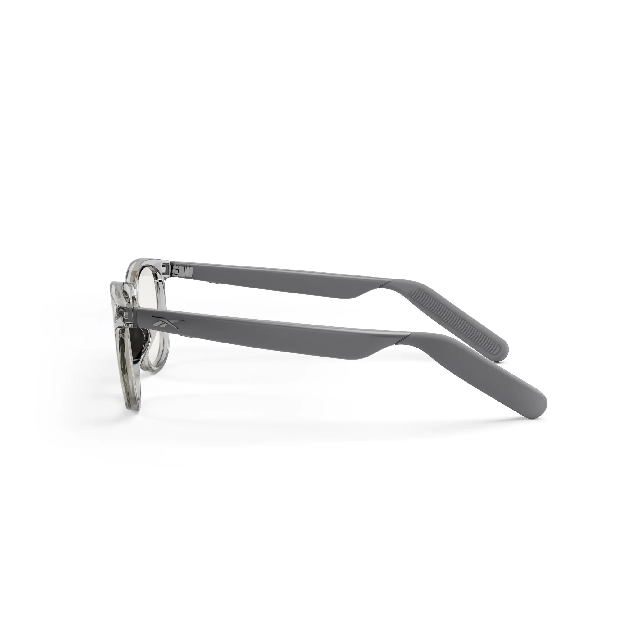 Side view of Reebok Thunder smart glasses with translucent round frames and wide, matte gray arms, shown on a white background.